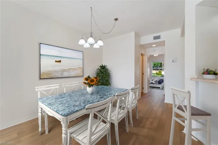 Dining area featuring visible vents, baseboards, light wood finished floors, and a notable chandelier