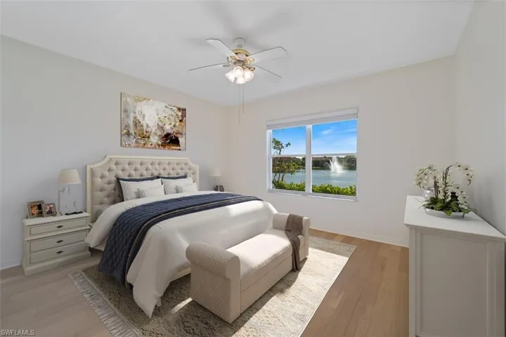 Bedroom with a water view, baseboards, light wood-type flooring, and a ceiling fan