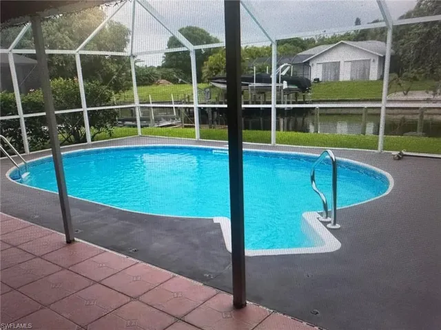 Outdoor pool with a lanai, a sunroom, and a patio area