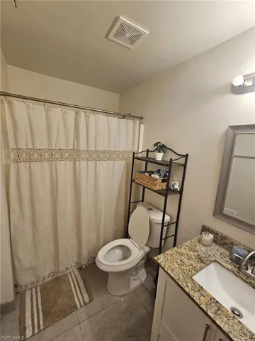 Bathroom with tile patterned floors, toilet, and vanity