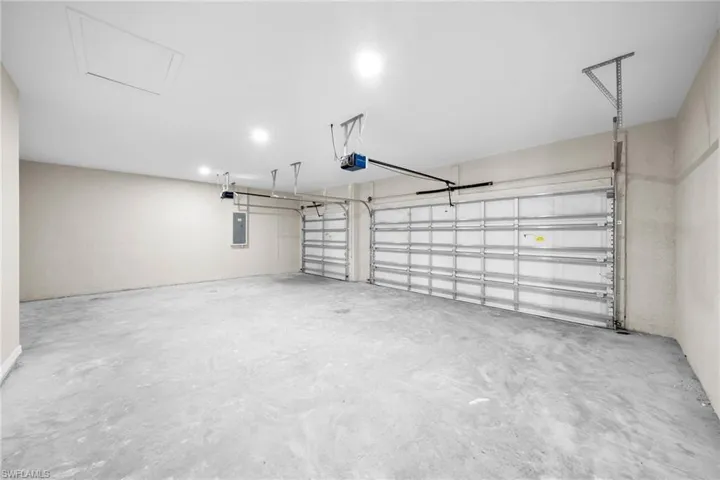 Garage featuring a garage door opener and electric panel