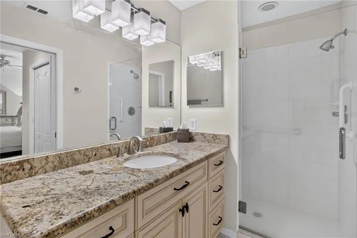 Bathroom vanity with a light-toned, speckled countertop, an undermount sink, and brushed nickel faucet