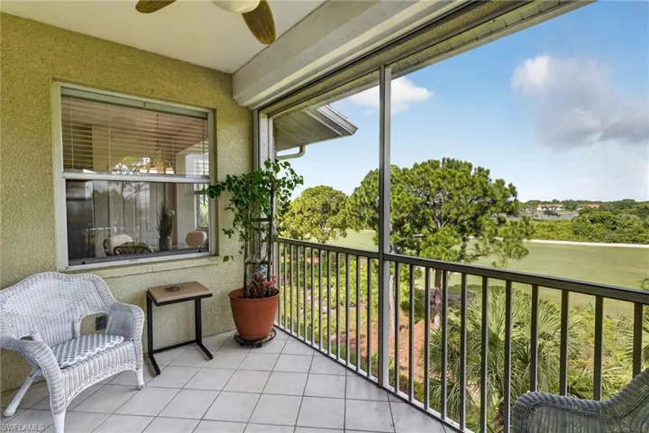 Screened balcony with tiled flooring, textured stucco walls, and a ceiling fan