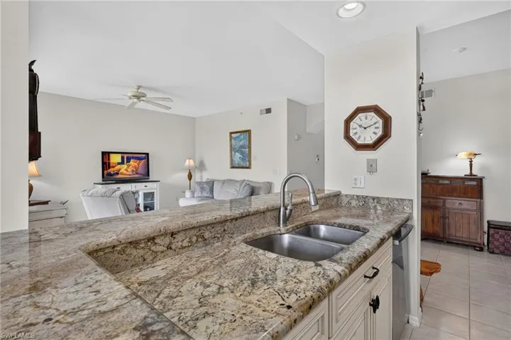 Kitchen island with a double stainless steel sink and a gooseneck faucet, set within a granite countertop