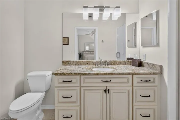 Vanity with a light-colored granite countertop and integrated sink
