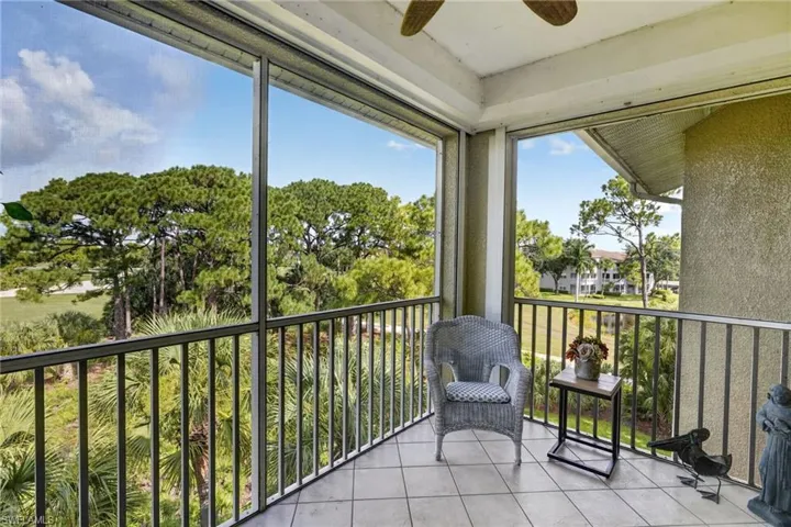 Screened lanai featuring tile flooring, a textured exterior wall, and a ceiling-mounted fan