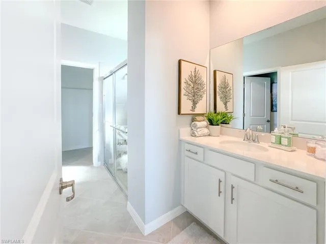 Bathroom featuring a shower stall, vanity, and light tile patterned floors