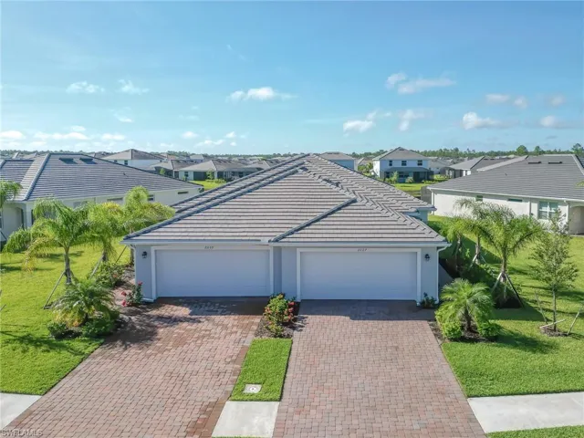 Ranch-style house with a residential view, a front lawn, stucco siding, and decorative driveway