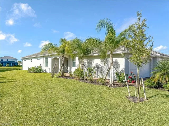 View of front of home featuring stucco siding, a front yard, and an attached garage