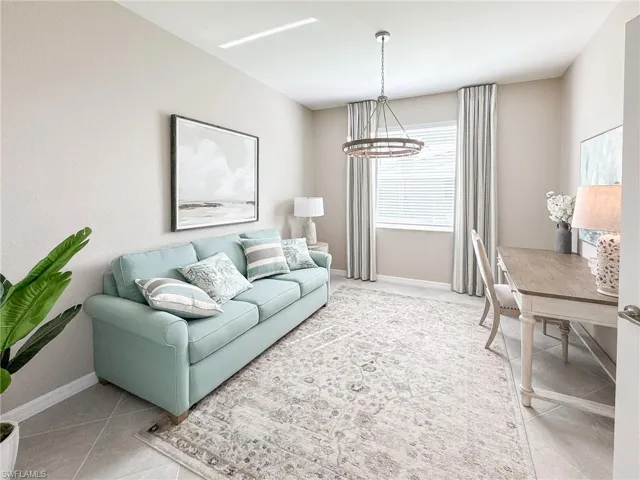 Living room featuring light tile patterned flooring and a chandelier