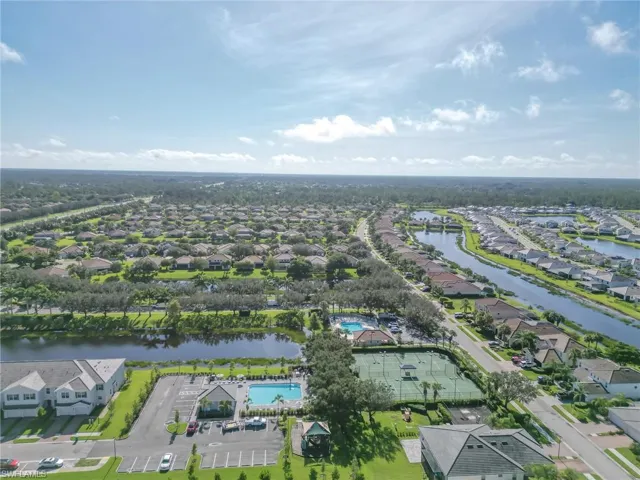 Aerial view of property and surrounding area with a nearby body of water and nearby suburban area