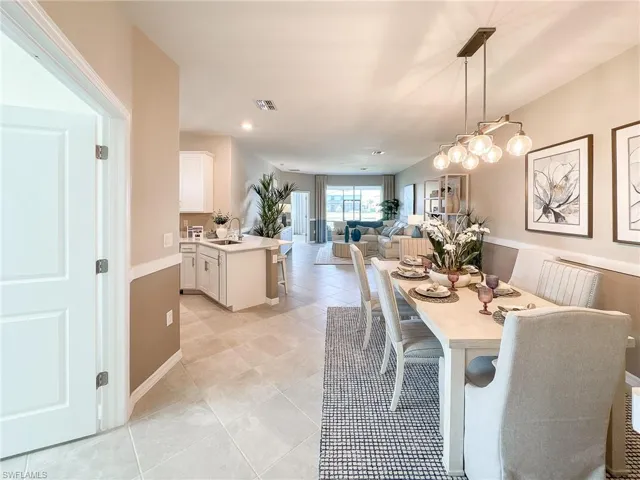 Dining space with light tile patterned floors and recessed lighting