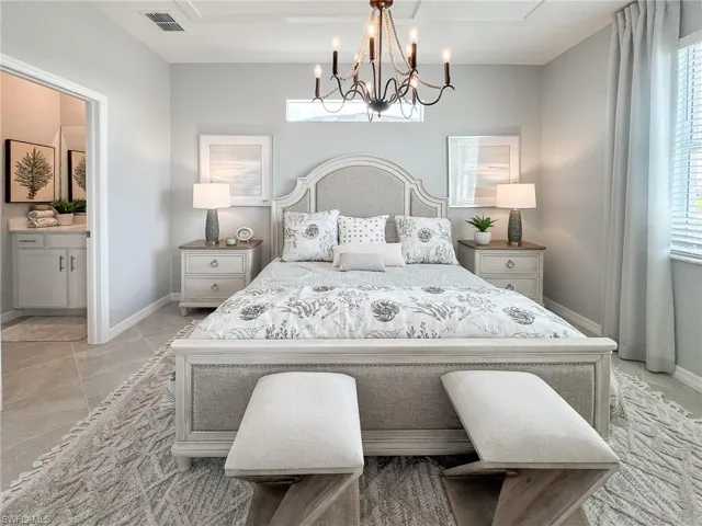 Bedroom with multiple windows, a chandelier, and connected bathroom