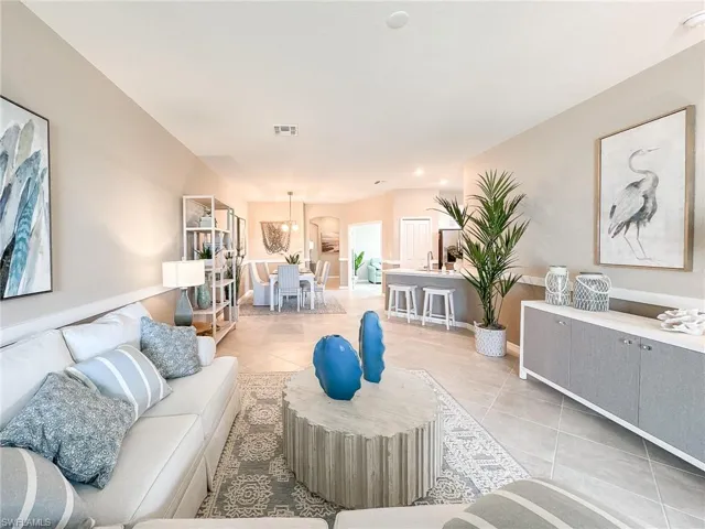Living room with light tile patterned floors and recessed lighting