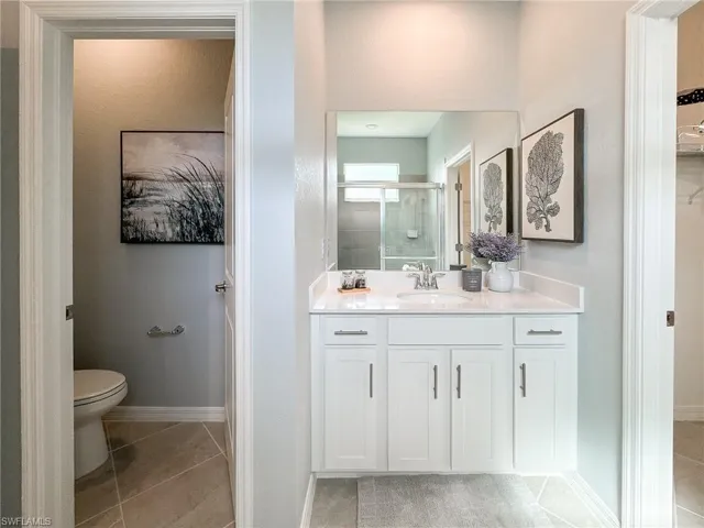 Bathroom featuring vanity, a stall shower, and light tile patterned flooring