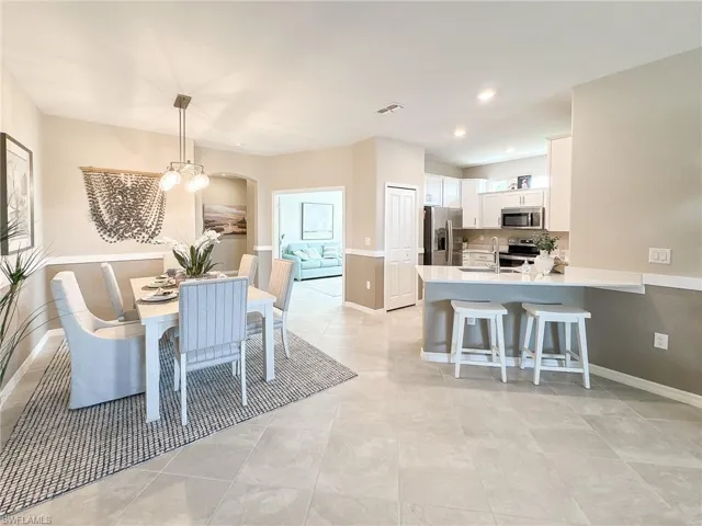 Dining area featuring recessed lighting, a chandelier, arched walkways, and light tile patterned floors