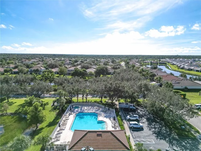 Aerial perspective of suburban area with a pool area and a large body of water