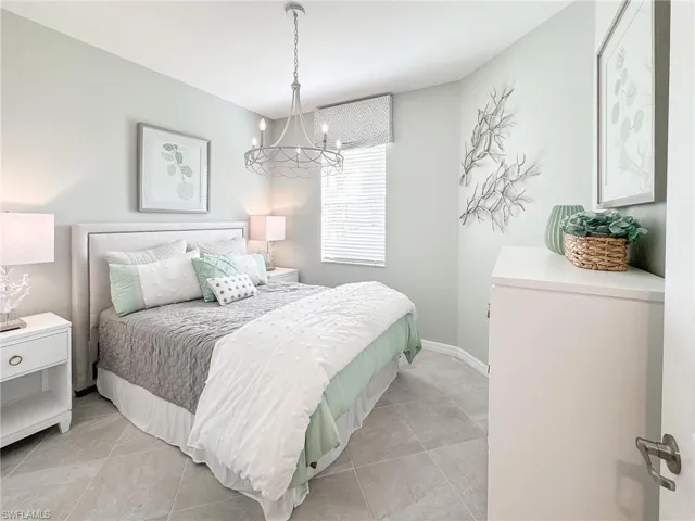 Bedroom featuring light tile patterned floors and a chandelier