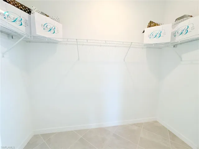 Walk in closet with light tile patterned floors