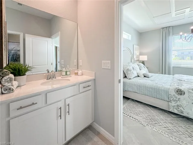 Ensuite bathroom with vanity and light tile patterned flooring