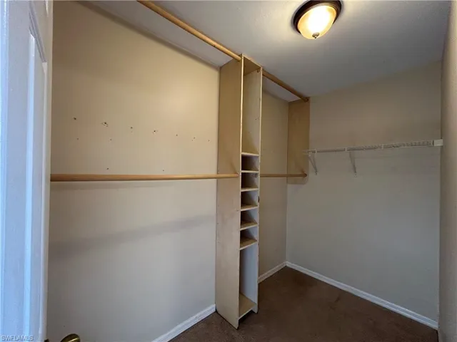 Walk in closet featuring dark carpet