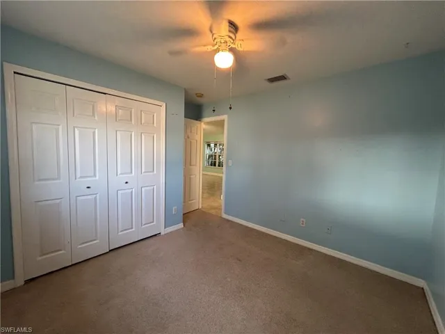 Unfurnished bedroom with carpet flooring, a ceiling fan, and a closet