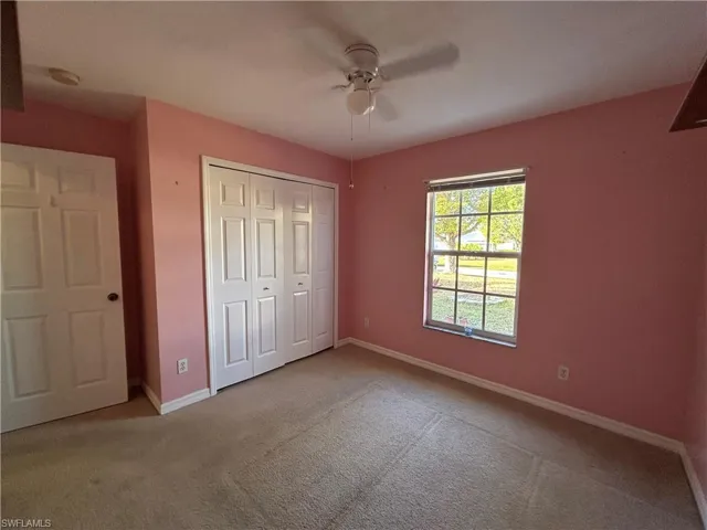Unfurnished bedroom featuring carpet floors, a closet, and a ceiling fan