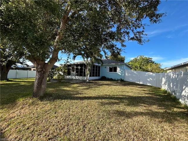 Back of house with a fenced backyard and a sunroom