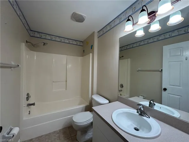 Full bathroom with shower / washtub combination, vanity, and light tile patterned flooring