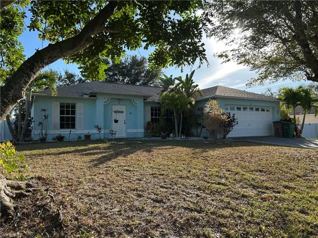 Single story home featuring stucco siding, a front lawn, an attached garage, and driveway