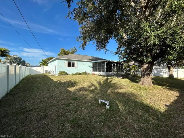 Back of property featuring a fenced backyard and a sunroom