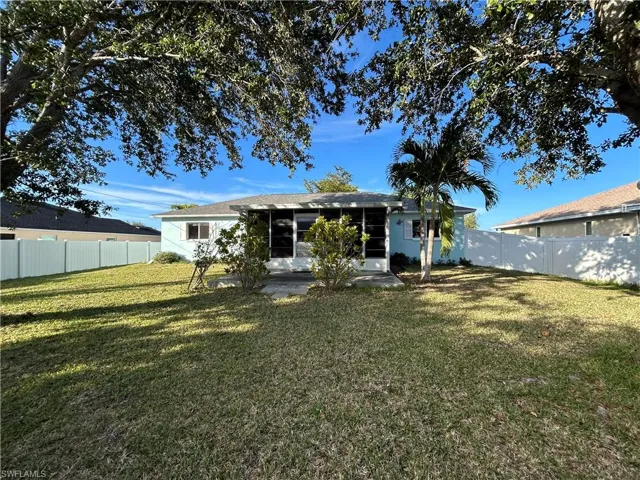 Back of house featuring a fenced backyard, a sunroom, and a patio area