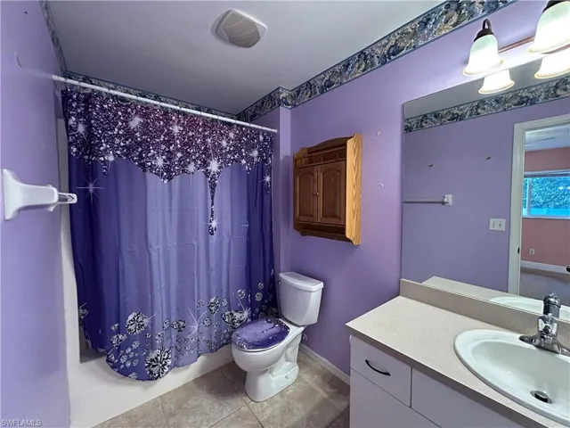 Bathroom with vanity, light tile patterned flooring, and shower / tub combo