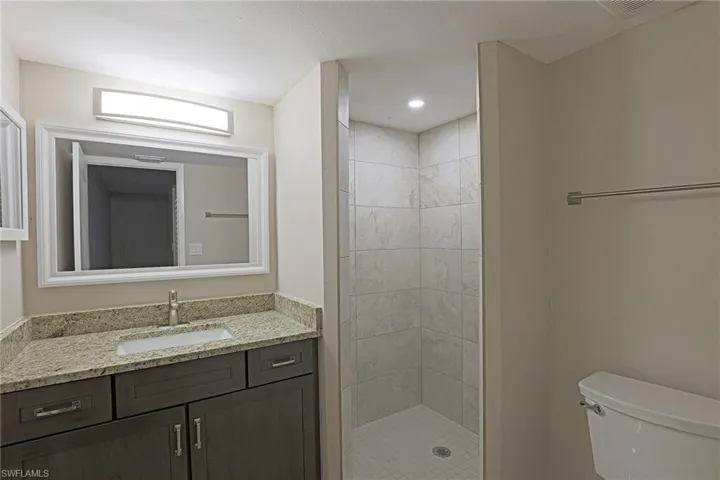 Full bathroom with vanity, a stall shower, and recessed lighting