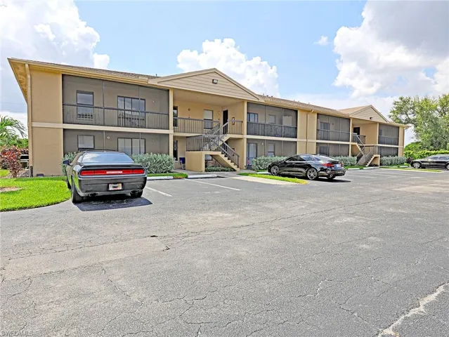 View of property featuring uncovered parking and stairway