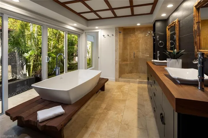 Bathroom featuring vanity, coffered ceiling, and separate shower and tub