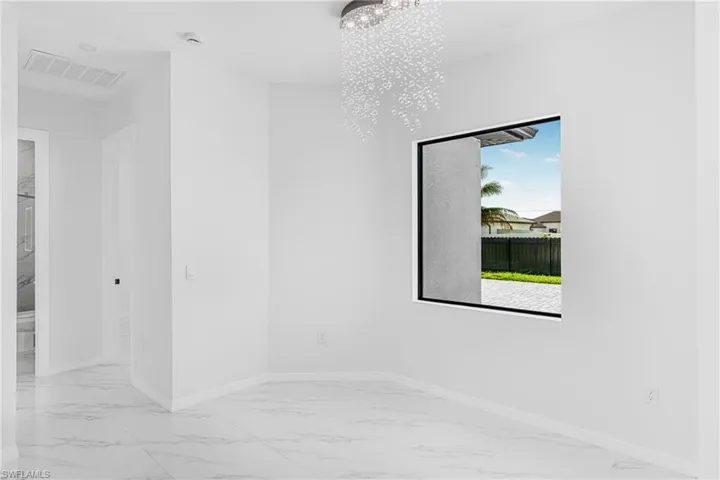 Unfurnished room featuring an inviting chandelier, baseboards, visible vents, and marble finish floor