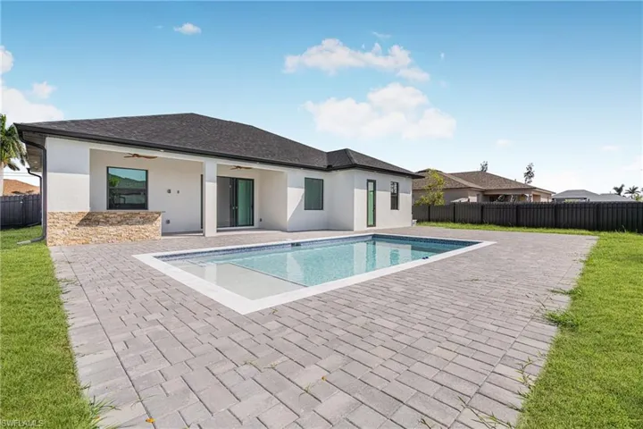 View of swimming pool featuring a patio area, fence, and a ceiling fan
