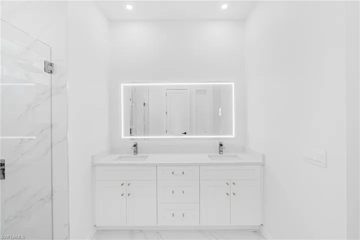 Bathroom featuring marble finish floor, a marble finish shower, and a sink