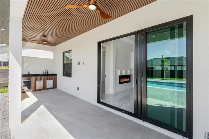 View of patio with a ceiling fan, a sink, and area for grilling