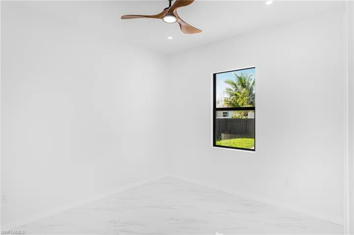 Unfurnished room featuring marble finish floor, baseboards, and recessed lighting