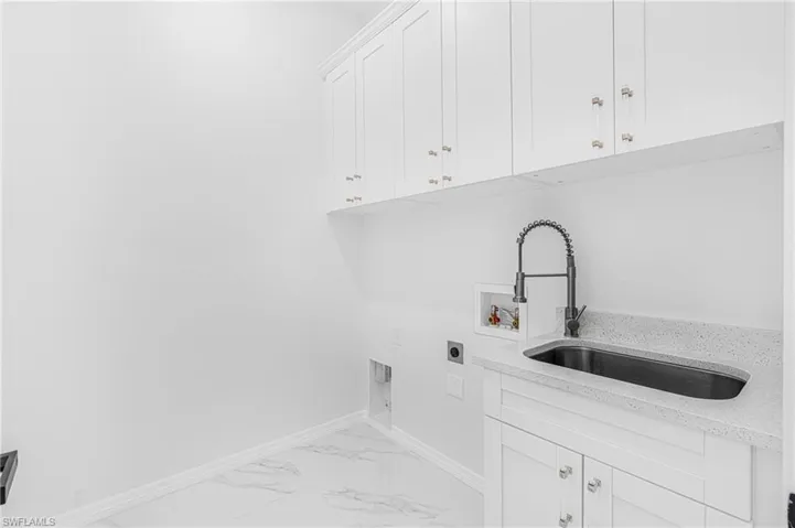 Laundry room with washer hookup, baseboards, marble finish floor, cabinet space, and electric dryer hookup