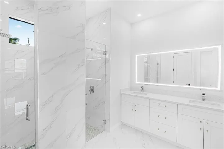 Bathroom with recessed lighting, marble finish floor, a sink, and a marble finish shower