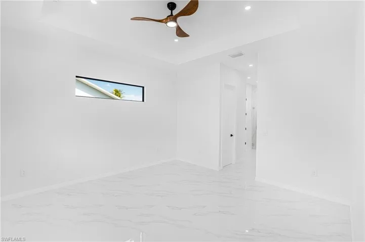 Spare room with a tray ceiling, recessed lighting, visible vents, and baseboards