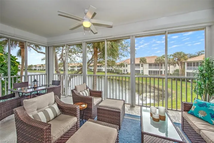 Sunroom / solarium featuring ceiling fan and a water view