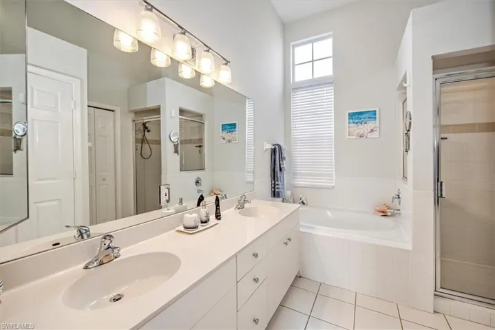 Bathroom featuring separate shower and tub, vanity, and tile patterned flooring