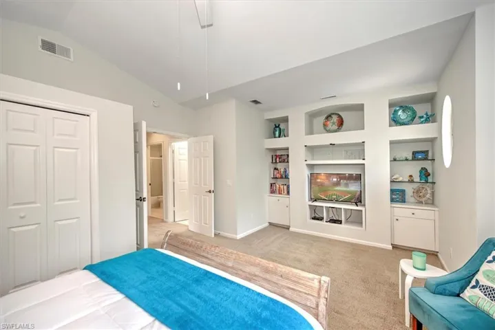 Bedroom featuring lofted ceiling, a closet, and light carpet