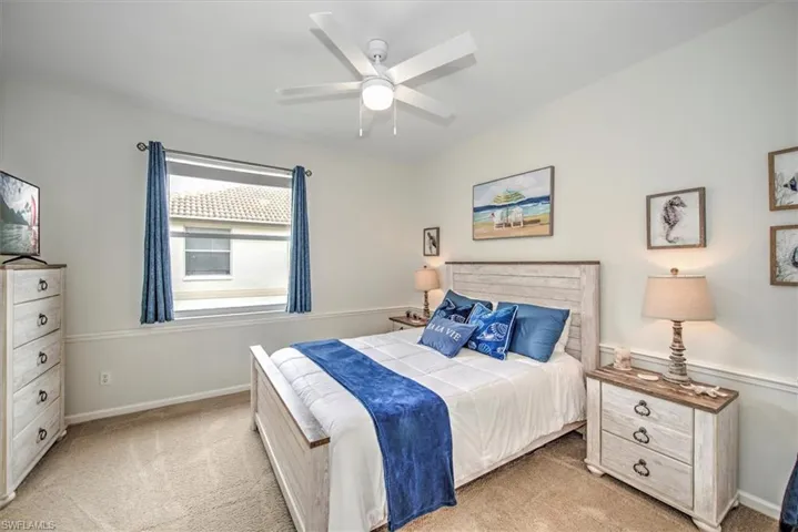 Carpeted bedroom featuring ceiling fan