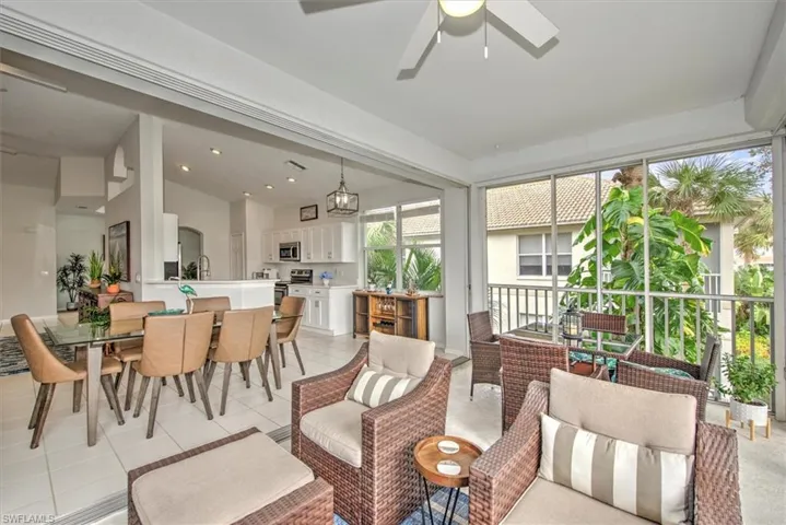 Sunroom / solarium featuring ceiling fan with notable chandelier and a wealth of natural light