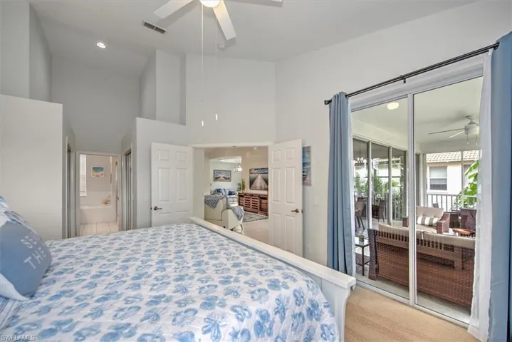 Bedroom featuring a high ceiling, ceiling fan, connected bathroom, and carpet floors